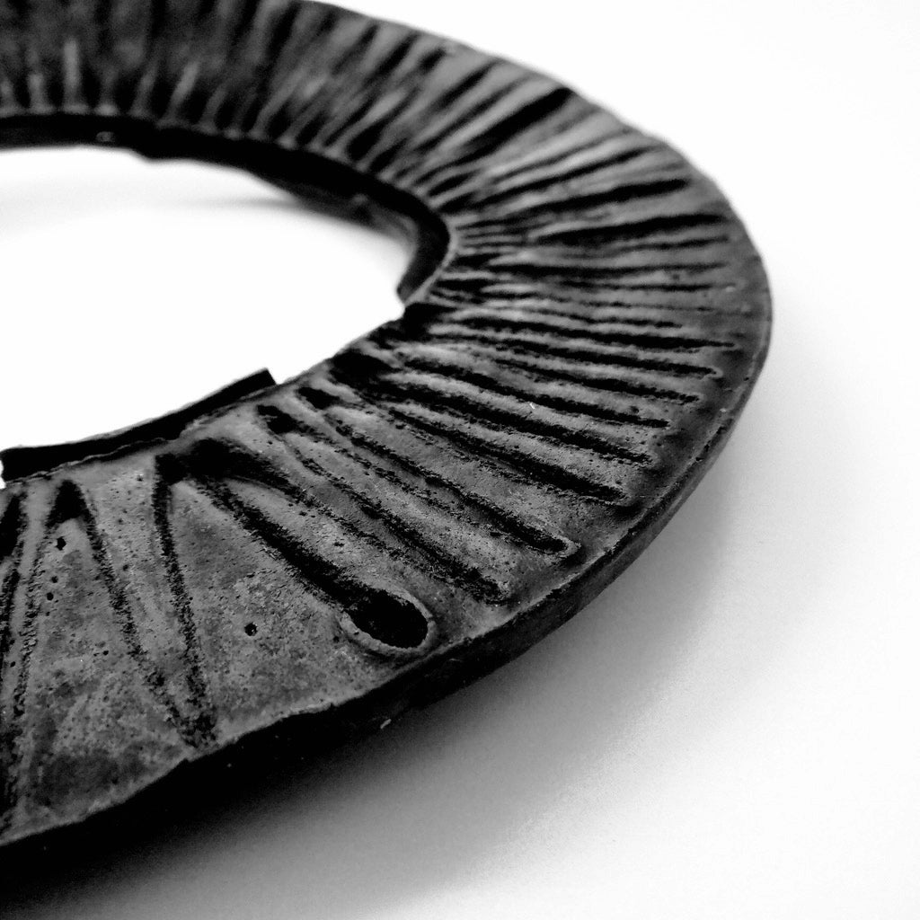 A black and white close up image, showing half of a car filter.