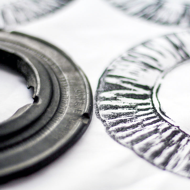 A black and white close up image showing a car filter and it's corresponding print.